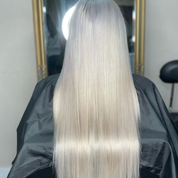 24 Inches Platinum Weave - A woman inside a salon wearing a black cape
