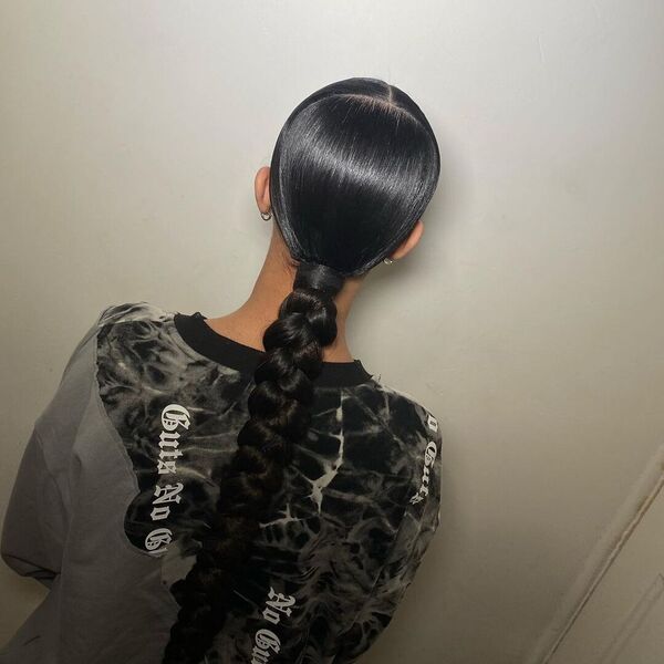 Middle Part Sleek Braided Ponytail - A woman wearing a printed sweater