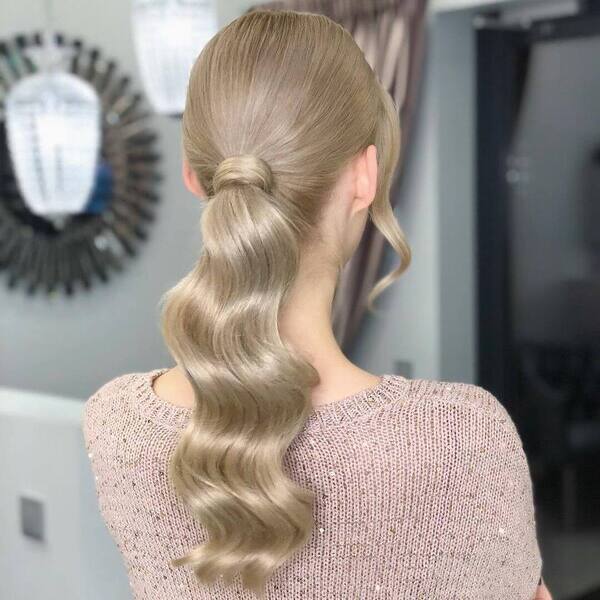 Beautiful and Classic Ponytail with Blonde and Bangs - A woman wearing a knitted blouse