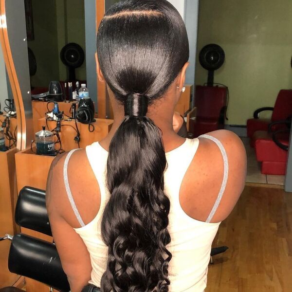 Low and Long Curly Ponytail - A woman inside a salon