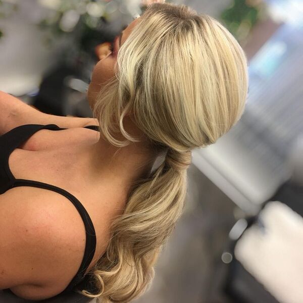 Low and Wrap Ponytail with Bangs - A woman wearing a black sleeveless